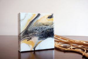 abstract painting done with gold, white and black acrylic and mixed media with resin finish on canvas